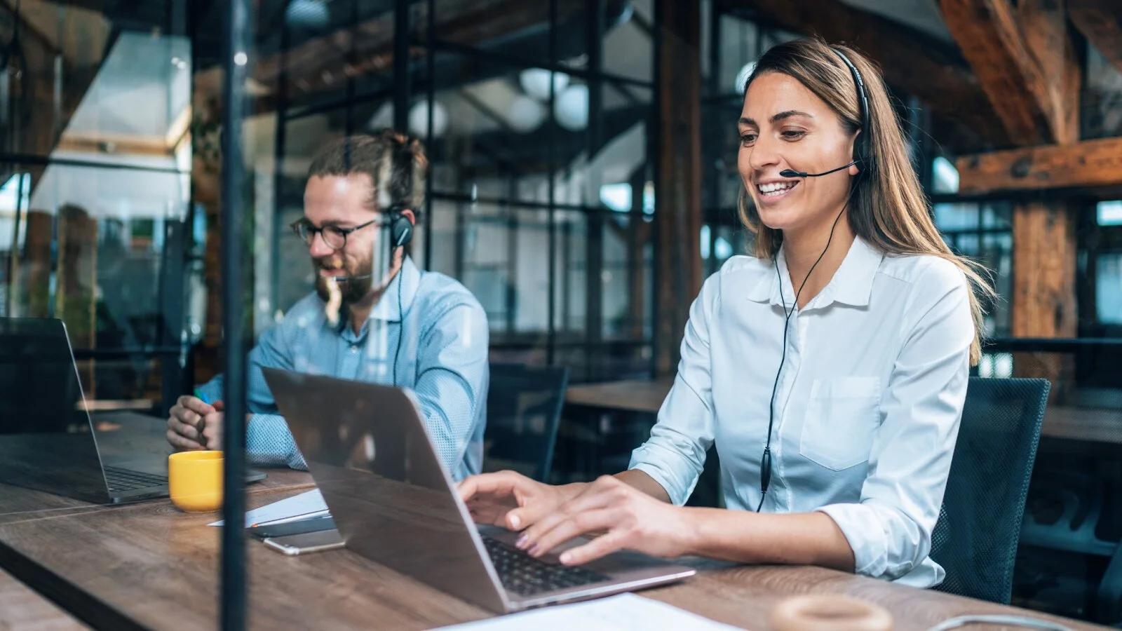Two professionals on headsets using laptops, representing virtual CIO services